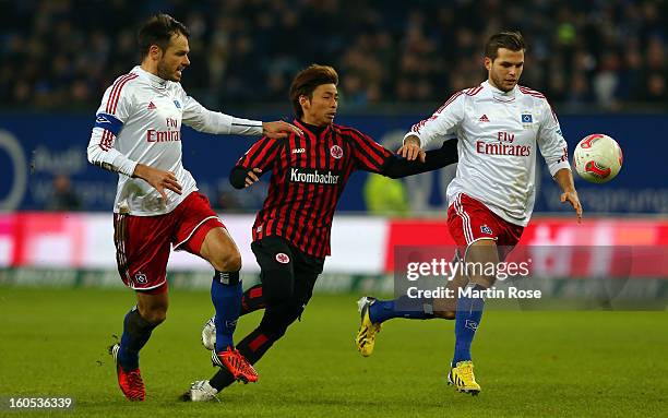 Heiko Westermann and Dennis Diekmeier of Hamburg and Takashi Inui of Frankfurt battle for the ball during the Bundesliga match between Hamburger SV...