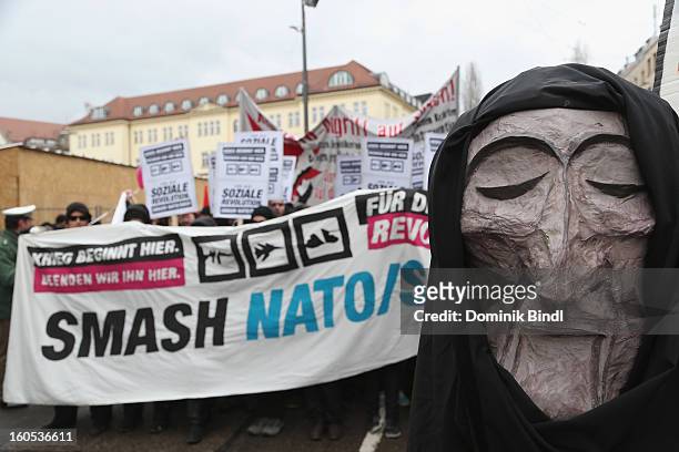 People hold signs as they demonstrate during a protest against the Munich Security Conference in the city centre on February 2, 2013 in Munich,...