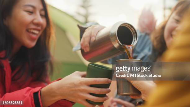 closeup group of happy asian friends drinking a cup of hot coffee for breakfast in vacation with camping caravan at morning. lifestyle travel nature. - flask imagens e fotografias de stock