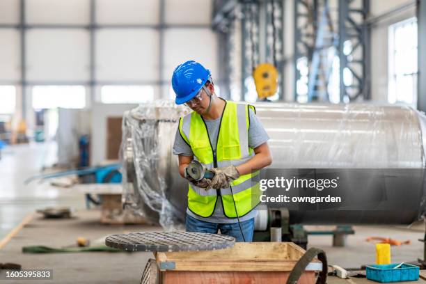 manual worker on a workshop grinding steel parts - sharpening stock-fotos und bilder