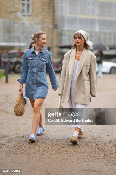Guest wears a white t-shirt, a blue denim buttoned / long sleeves short shirt dress, a brown wickers handbag, pale blue suede and white leather logo...