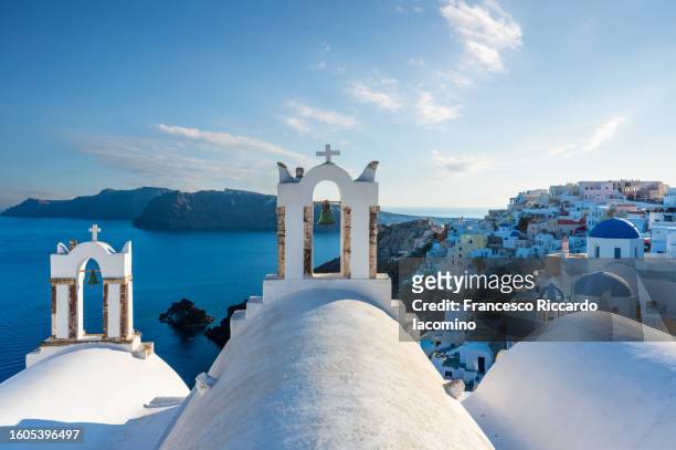 oia, santorini island, cyclades, greece.  cityscape, houses and churches with bell, sea on background - santorini stock pictures, royalty-free photos & images