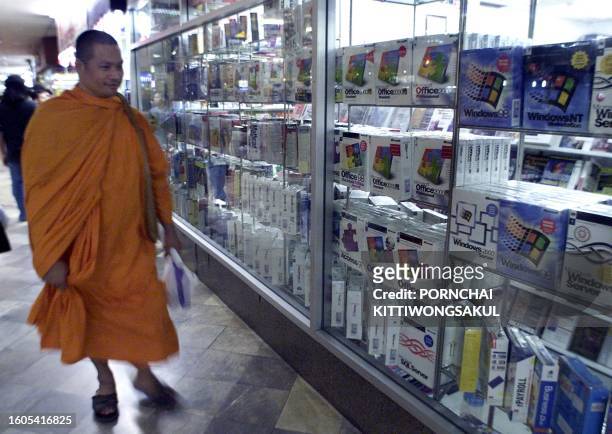 Thai Buddhist monk walks pass software program shop at Pantip Plaza in Bangkok on 9 April 2000. Fearing Buddhism is becoming irrelevant in modern...