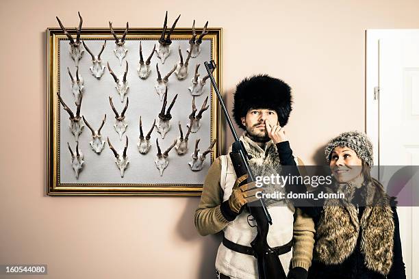 funny portrait of hunter with shotgun and his wife, antlers - hunting trophy stock pictures, royalty-free photos & images