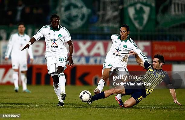 Savvas Tsampouris of Tripolis slides in as Pape Habib Sow and Toche of Panathinaikos attack during the Superleague match between Asteras Tripolis and...