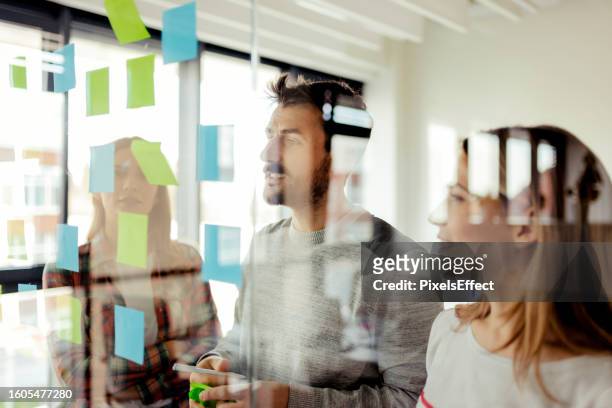 arranging sticky notes on a glass wall - mind map stock pictures, royalty-free photos & images