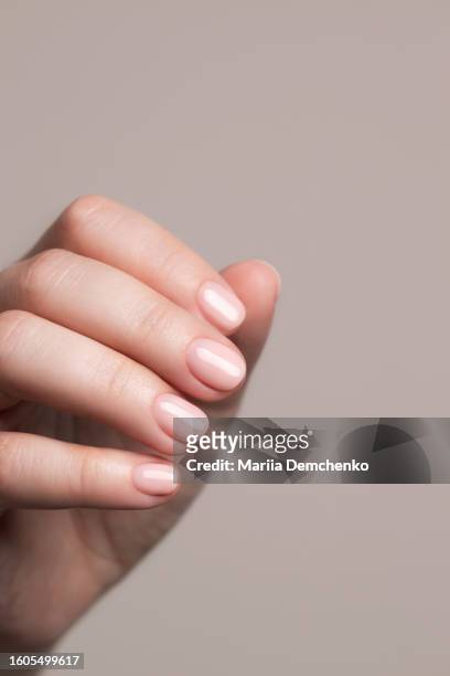hand with beautiful manicure - pink gel nails - huidkleurig stockfoto's en -beelden