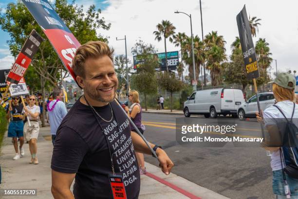 Actor Adam Conover with members and supporters of SAG-AFTRA and WGA picket in front of Paramount Pictures studios on August 09, 2023 in Los Angeles,...