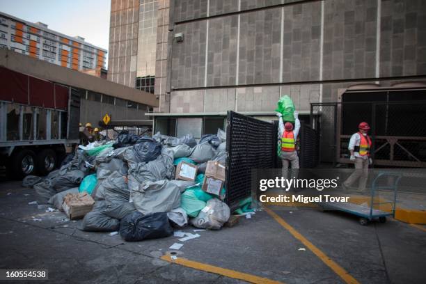 Cleaning workers carry documents to the garbage depot at the PEMEX administrative building on February 01, 2013 in Mexico City, Mexico. Pemex is...