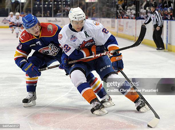 Gabe Guentzel of the Norfolk Admirals gets his stick under Nino Niederreiter of the Bridgeport Sound Tigers as he skates with the puck during an...