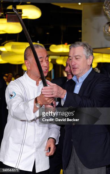 Chef Nobu Matsuhisa and Actor Robert De Niro handle a sword that was used for a ribbon cutting ceremony during a preview for the Nobu Restaurant and...