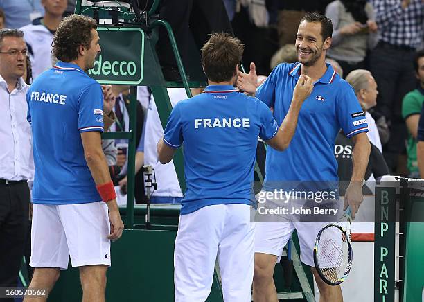 Arnaud Clement, coach of France congratulates Julien Bennetteau and teammate Michael Llodra of France after their victory in the doubles match...