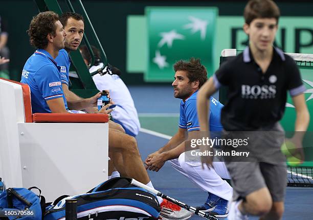 Julien Bennetteau and Michael Llodra of France listen to Arnaud Clement, coach of France during their doubles match against Jonathan Erlich and Dudi...