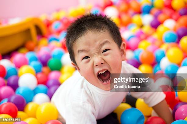 boy on the balls - ball pit stock pictures, royalty-free photos & images