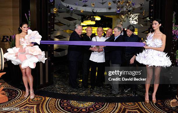Standing between two models wearing orgami style dresses President of Caesars Entertainment Corp. Western Division Tom Jenkin, Meir Teper, chef Nobu...