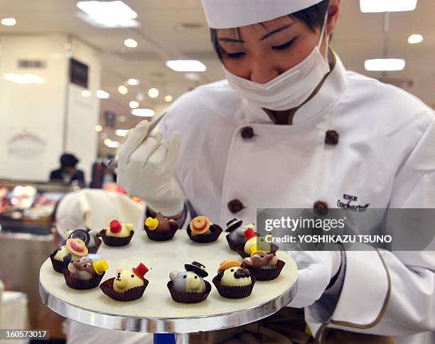 Japan's sweet shop Goncharoff chocolatier puts the finishing touches to animal-shaped chocolates at Takashimaya department store's Valentine's Day...