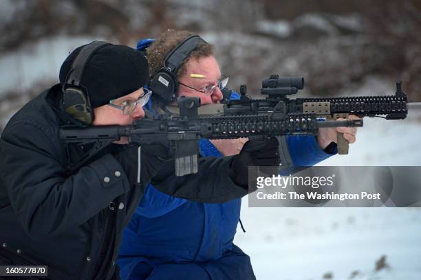 Gun enthusiasts Robert Farago and David Kenik practice shooting side-by-side with Kenik's AR-15 automatic rifles at a shooting range in Manville, RI...