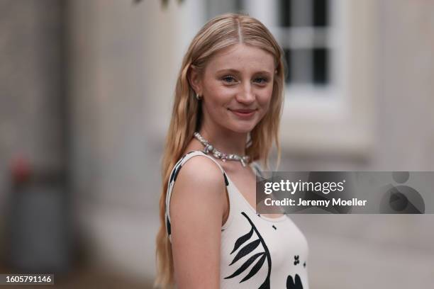 Trixi Giese seen outside Marimekko show wearing Pandora charm necklace in silver, white arm free dress with ruffled skirt part and black flower...