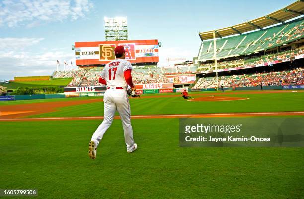 Shohei Ohtani of the Los Angeles Angels runs out of the dugout to the pitchers mound to start the game against the San Francisco Giants at Angel...