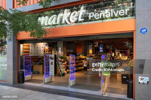 Customer enters the French multinational supermarket chain, Carrefour Market, in Spain.