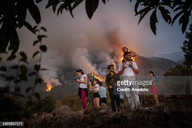 Neighbors of the town of Aguamansa try to clean the surroundings of their homes before the threat of uncontrolled fire that goes down the slopes of...