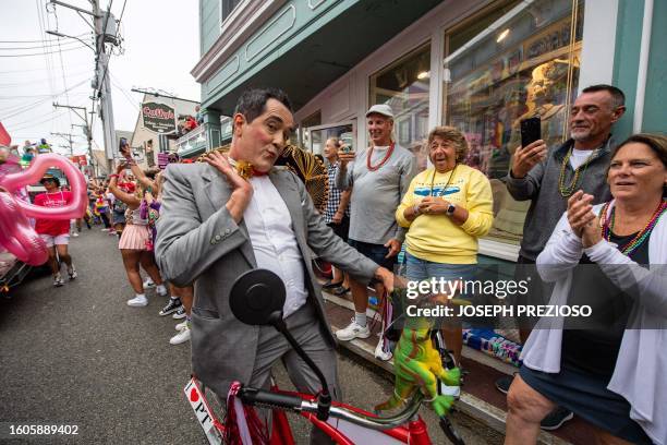 Person dressed as Pee-Wee Herman rides a bike during the 45th Annual Provincetown Carnival Parade in Provincetown, Massachusetts, on August 17, 2023....