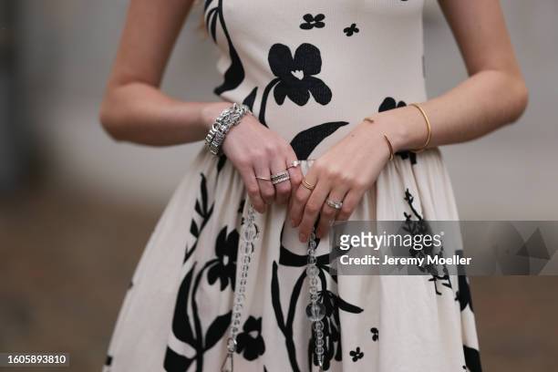 Trixi Giese seen outside Marimekko show wearing Pandora charm necklace in silver, white arm free dress with ruffled skirt part and black flower...