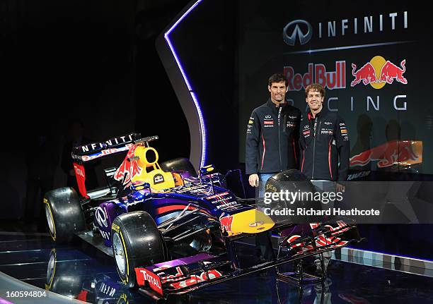 Drivers Mark Webber of Australia and Sebastian Vettel of Germany pose along side the new car during the Infiniti Red Bull Racing RB9 launch on...