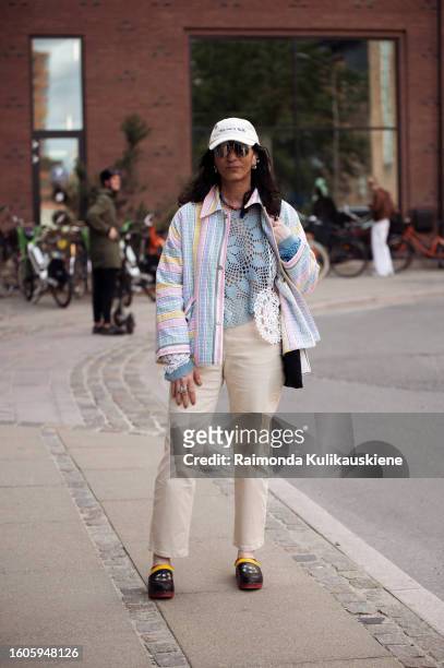 Susan Stjernberger wears white pants, blue knitted top, clorourful shirt and white cap outside Lovechild 1979 during the Copenhagen Fashion Week...