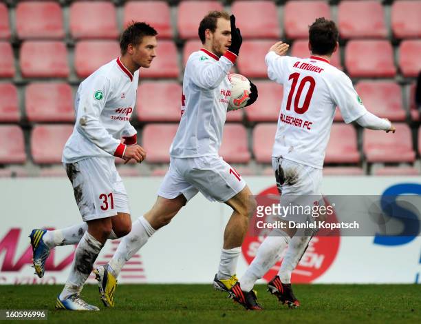 Timo Furuholm of Halle celebrates his team's first goal with team mates Kristian Kojola and Anton Mueller during the third Bundesliga match between...