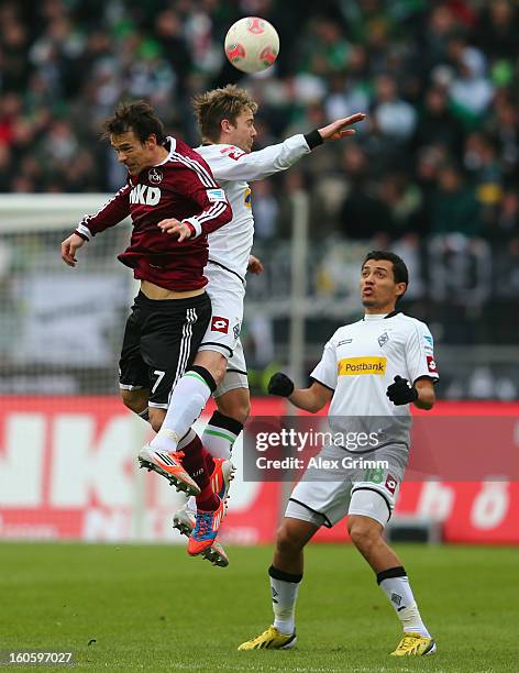 Markus Feulner of Nuernberg is challenged by Thorben Marx and Juan Arango of Moenchengladbach during the Bundesliga match between 1. FC Nuernberg and...