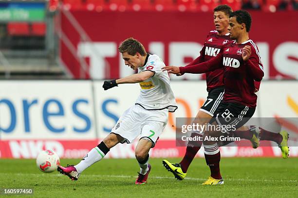 Patrick Herrmann of Moenchengladbach tries to score ahead of Timothy Chandler and Mike Frantz of Nuernberg during the Bundesliga match between 1. FC...