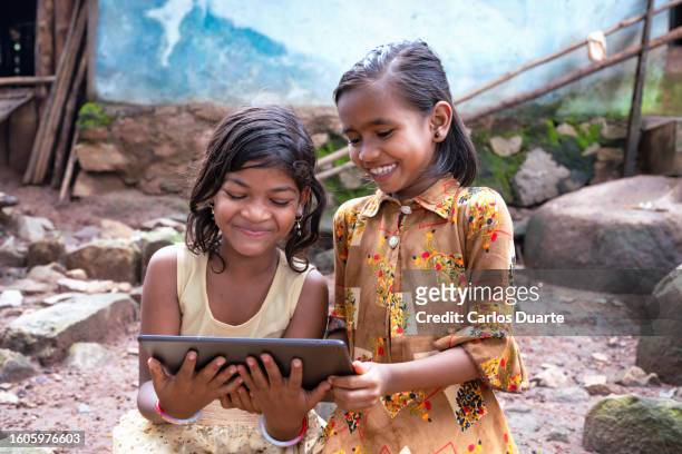 two girls from a tribe in the indian region of odisha have a great time using a digital tablet for the first time. they laugh a lot. - game 2 2 stock pictures, royalty-free photos & images
