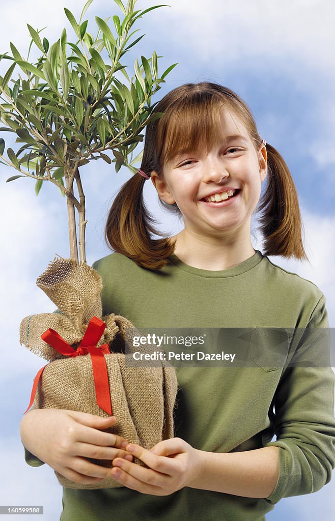 Girl holding homegrown olive tree