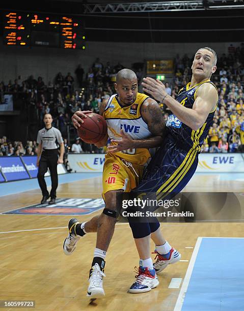 Ronnie Burrell of Oldenburg challenges for the ball with Sven Schultze of Berlin during the BBL game between EWE Baskets Oldenburg and Alba Berlin at...