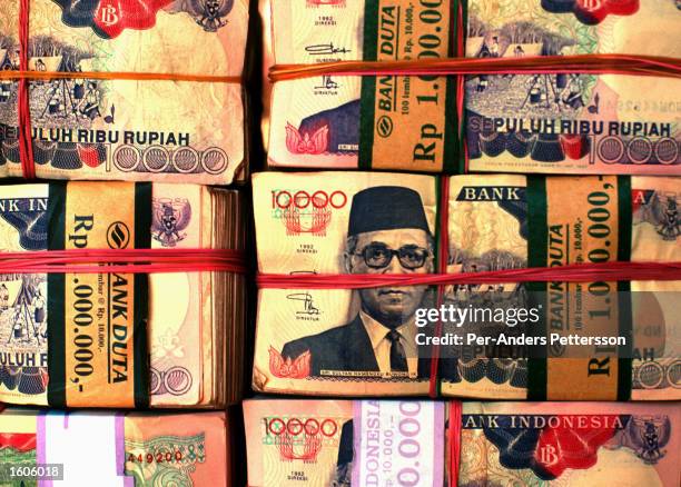 Stacks of Rupiah, the Indonsian currency, sit at a currency dealer February 23, 1998 at a street in Jakarta, Indonesia. The currency has lost a lot...