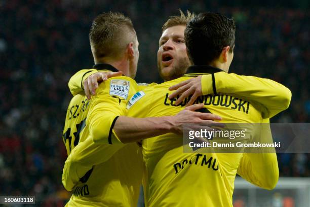 Robert Lewandowski of Dortmund celebrates with teammates Lukasz Piszczek and Jakub Blaszczykowski during the Bundesliga match between Bayer 04...