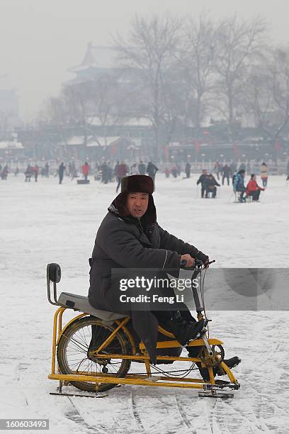 Man rides on specially constructed "ice-bicycle" on the frozen Houhai Lake during severe pollution on February 3, 2013 in Beijing, China. Houhai Lake...