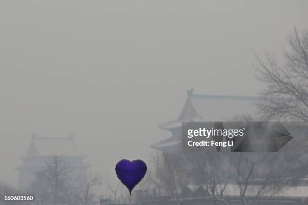 Heart-shaped balloon is seen in front of Drum Tower at Houhai Lake during severe pollution on February 3, 2013 in Beijing, China. Houhai Lake is a...