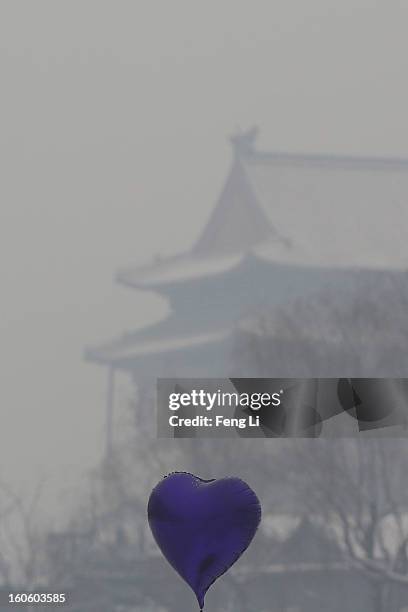 Heart-shaped balloon is seen in front of Drum Tower at Houhai Lake during severe pollution on February 3, 2013 in Beijing, China. Houhai Lake is a...