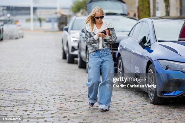 Guest wears white laced jacket, denim jeans outside TG Botanical during the Copenhagen Fashion Week Spring/Summer 2024 on August 10, 2023 in...