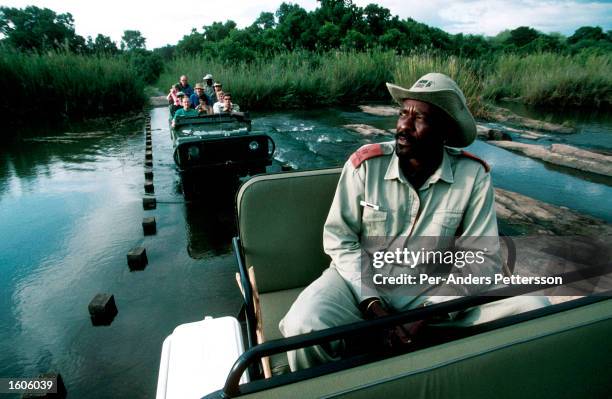 Tourists on safari ride in open Land Rovers September 13, 1997 at Mala Mala, an exclusive game lodge in Kruger Park, South Africa. South Africa has...