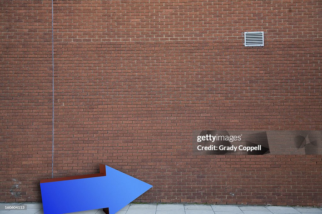 Arrow against a brick wall background