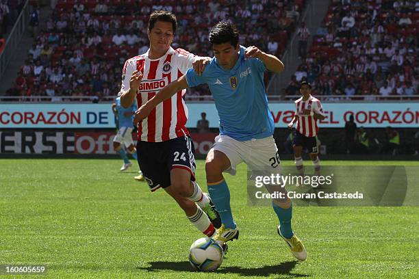 Sergio Perez Moya of Chivas Guadalajara and Angel Luis Mendoza of San Luis fight for the ball during a match of the Clausura Liga MX Round 5 in...