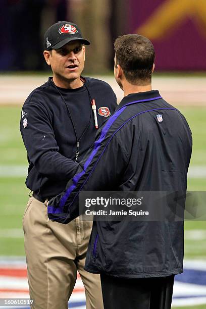 Head coach Jim Harbaugh of the San Francisco 49ers shakes hands with his brother head coach John Harbaugh of the Baltimore Ravens prior to Super Bowl...