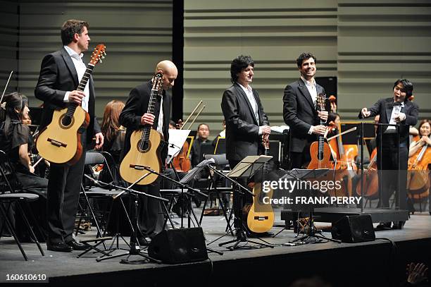 Guitarists Emmanuel Rossfelder, Fernando Espi, Juan Manuel Canizares, and Pablo Sainz Villegas salute after performing with the Yokohama Sinfonietta...