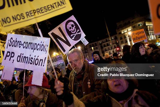 Protestors hold placards as they gather during a demonstration against alleged corruption scandals implicating the PP , on the streets of Madrid on...