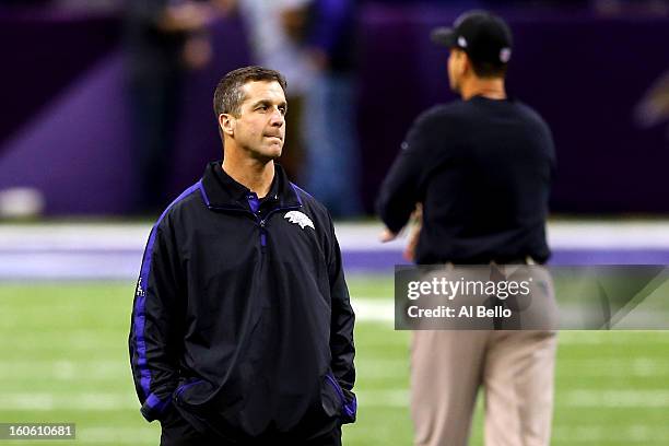 Head coach John Harbaugh of the Baltimore Ravens and head coach Jim Harbaugh of the San Francisco 49ers look on during warm ups prior to Super Bowl...
