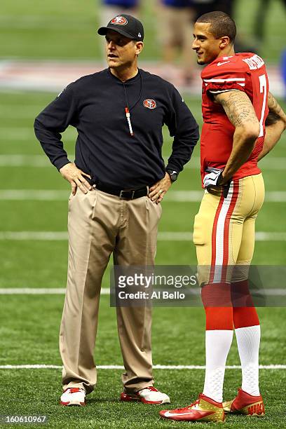 Head coach Jim Harbaugh speaks to Colin Kaepernick of the San Francisco 49ers during warm ups prior to Super Bowl XLVII at the Mercedes-Benz...