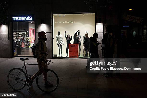 Women at a shop react while protestors pass by during a demonstration against alleged corruption scandals implicating the PP in the streets of Madrid...